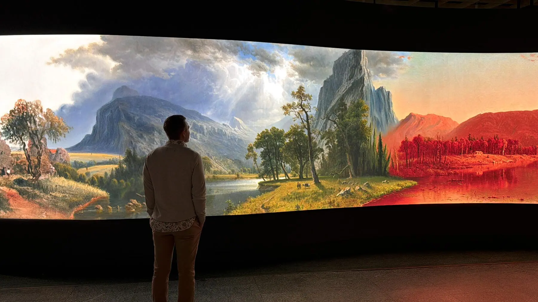 A visitor viewing the Infinite Landscape interactive, a collection landscape painting transitioning through the seasons across a curved panoramic screen