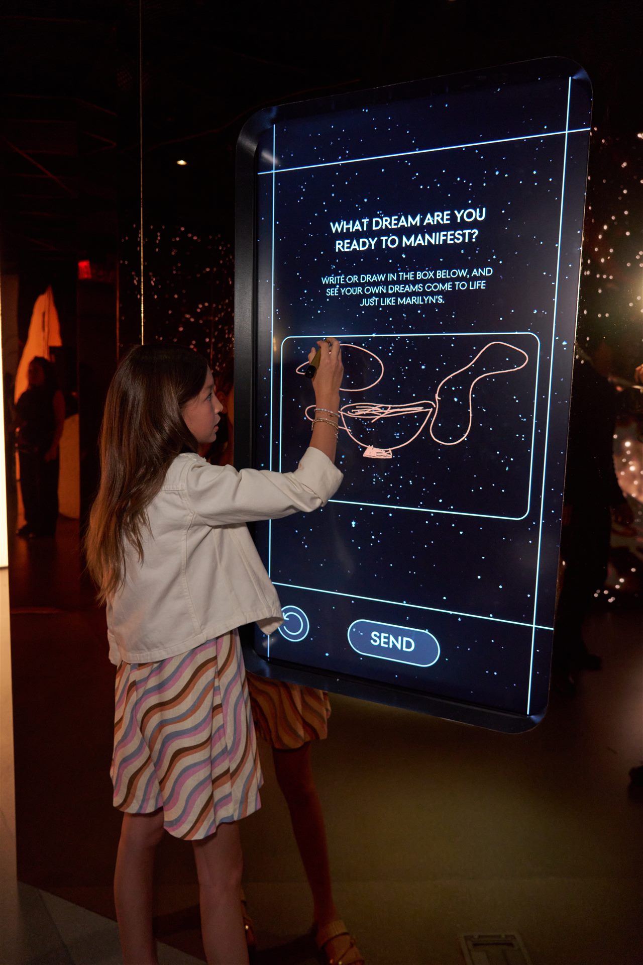 A visitor drawing her wish at a New Beginnings kiosk